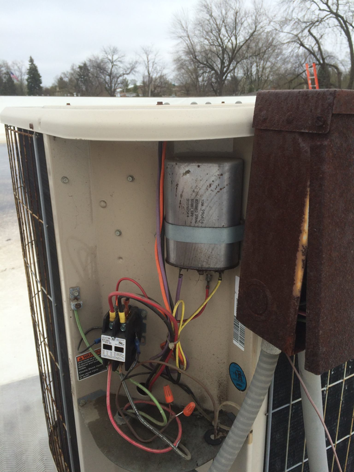 Close-up of internal electrical components and wiring inside an HVAC unit, serviced by Corbe Heating and Air Conditioning in Elgin, IL.