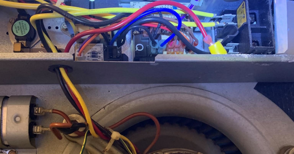 Close-up of internal HVAC wiring and a fan motor, showing service by Reeds heating and air LLC in Mobile, AL.