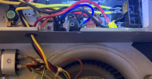 Close-up of internal HVAC wiring and a fan motor, showing service by Reeds heating and air LLC in Mobile, AL.