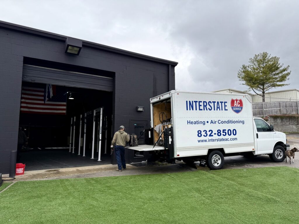 Interstate AC service van parked at a commercial job site with a technician in Nashville, TN.