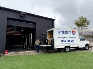 Interstate AC service van parked at a commercial job site with a technician in Nashville, TN.