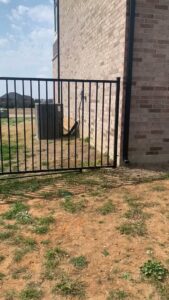A black iron fence installed to protect an outdoor AC unit by Iron Fence Services, LLC in Lancaster, TX