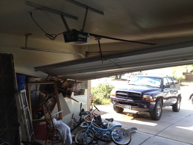 A jammed garage door that is off its tracks, requiring immediate repair from Able Garage Door Service, LLC in Tucson, AZ.