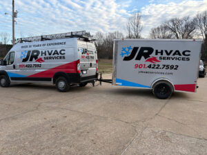 A JR HVAC Services branded service van with ladders and a matching trailer, ready for jobs in Memphis, TN.