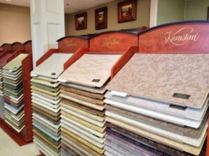 Karastan carpet samples displayed on racks in the showroom at Jimmie Lyles Flooring Gallery in Flowood, MS