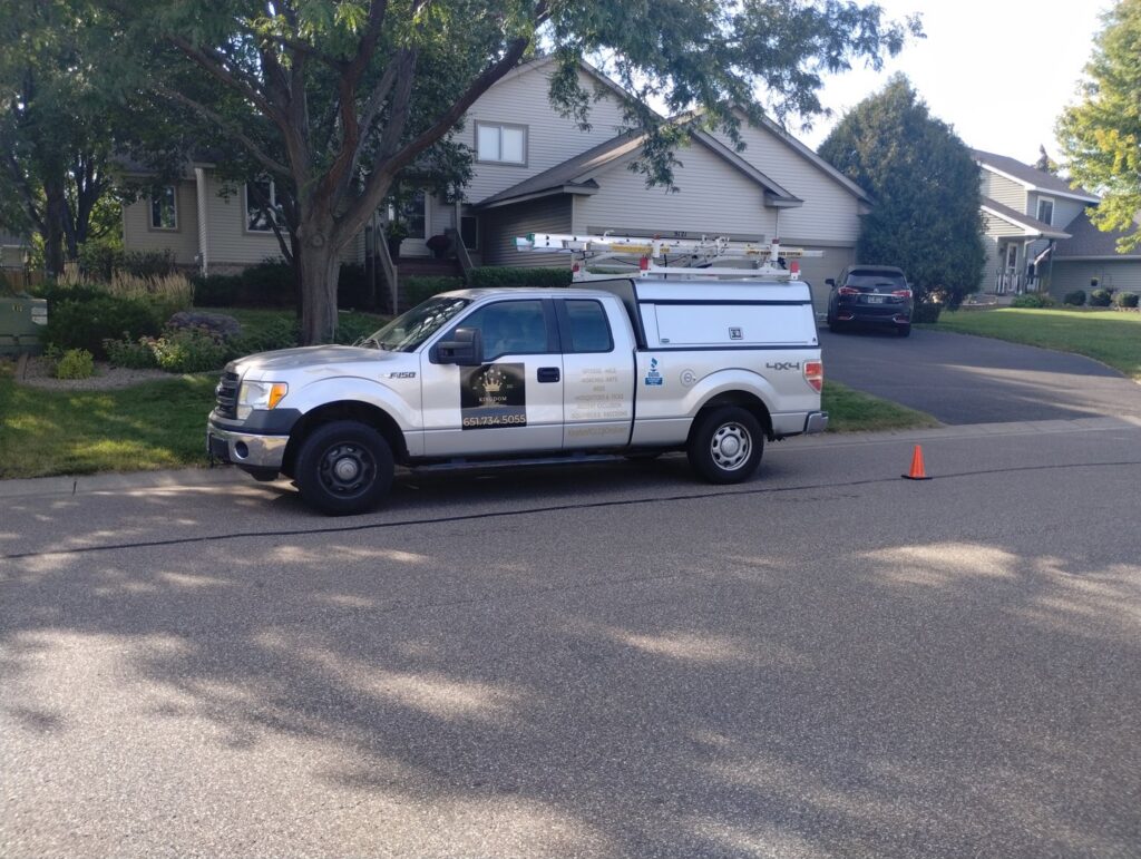 A Kingdom Pest Control & Services truck parked on a residential street in Brooklyn Park, MN, ready for a pest control service.