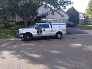 A Kingdom Pest Control & Services truck parked on a residential street in Brooklyn Park, MN, ready for a pest control service.