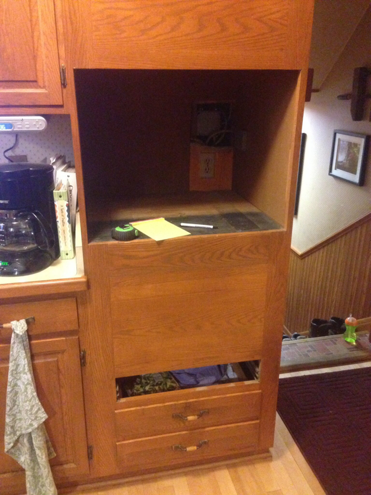 Electrical wiring and outlets visible in a kitchen cabinet opening, ready for appliance installation by Zsori Electric in Waukesha, WI.