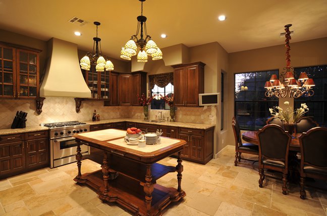 A kitchen featuring elegant chandeliers and functional under-cabinet lighting installed by Castle Electrical & Lighting in Scottsdale, AZ.