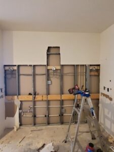 Kitchen wall during renovation showing exposed electrical wiring and boxes by Neptune Electric in Virginia Beach, VA.