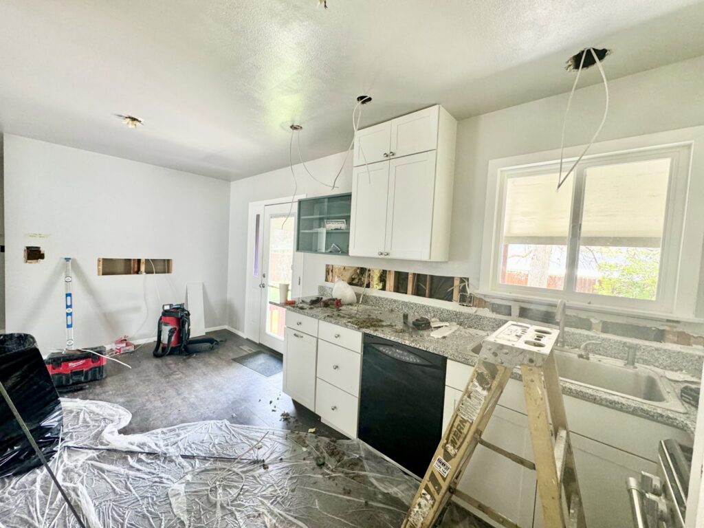 Kitchen electrical rough-in during renovation with exposed wires and ladder by P.H. Electric in Soulsbyville, CA.