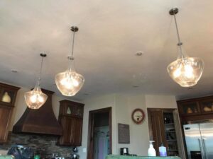 Elegant glass pendant lights installed in a modern kitchen by TGR Electric LLC for a client in Carmel, IN.