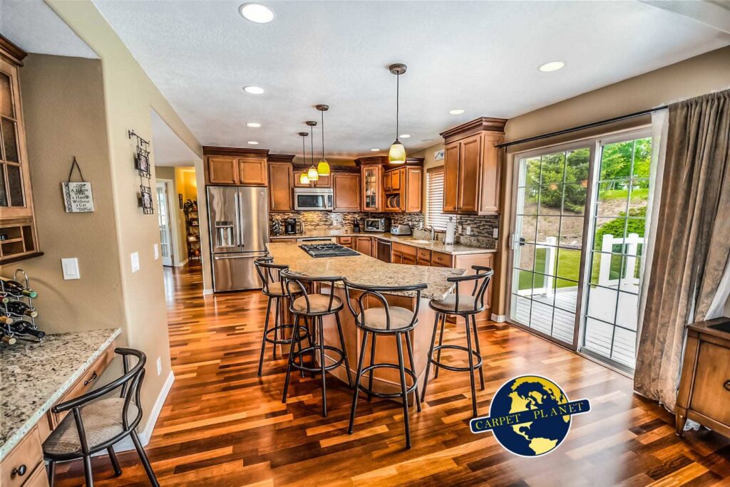 A beautifully installed hardwood floor in a modern kitchen by Carpet Planet LLC in Colorado Springs, CO.