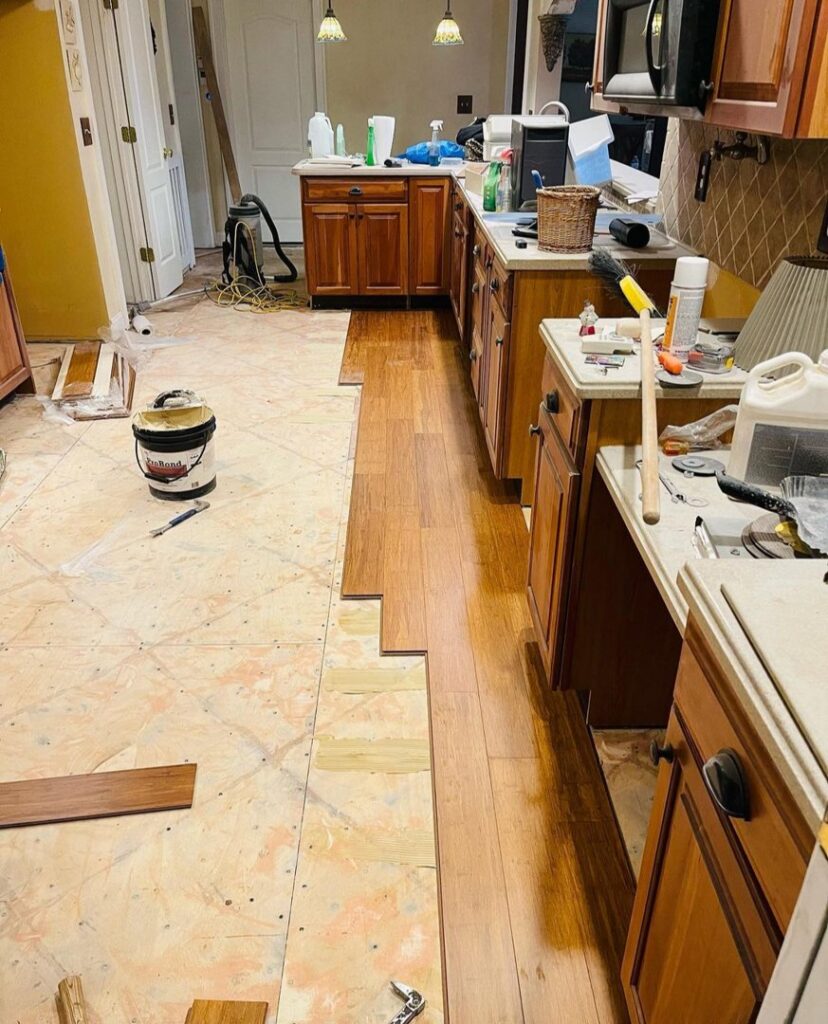 Hardwood floor installation in progress in a kitchen, showing new planks being laid by Isad Home Floor in Bridgeport, CT.