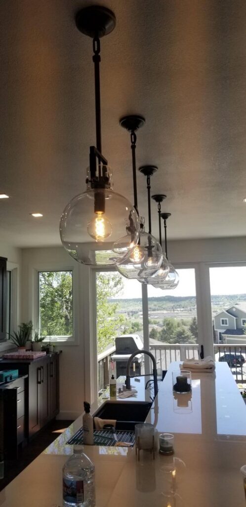Kitchen island illuminated by a row of modern pendant lights installed by Access Electrical in Indianapolis, IN.