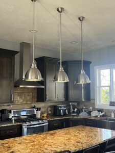 Three pendant lights installed above a kitchen island by Powered Electrical & Lighting Services LLC in Springfield, MO.
