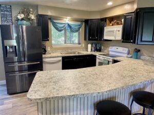 Newly installed light wood-look laminate flooring in a kitchen by Carpets By Cal Inc in Vernal, UT