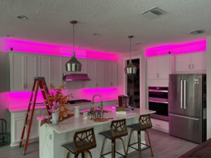Kitchen with vibrant pink LED strip lighting installed above and below cabinets by T.E.C Electrical Contracting, LLC in Jacksonville, FL
