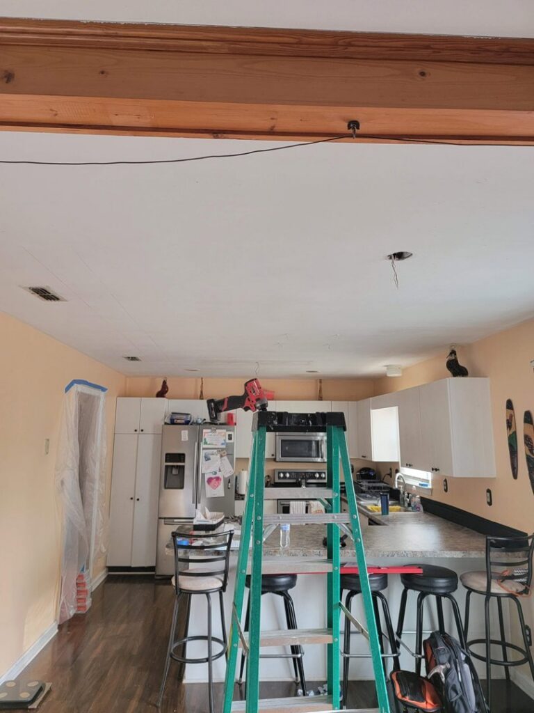Kitchen with a ladder and tools, showing an exposed wire for light fixture installation by Neptune Electric in Virginia Beach, VA.