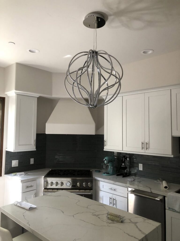 A modern kitchen with a newly installed decorative light fixture and recessed lighting by CLB Electric Corporation in Norwalk, CA