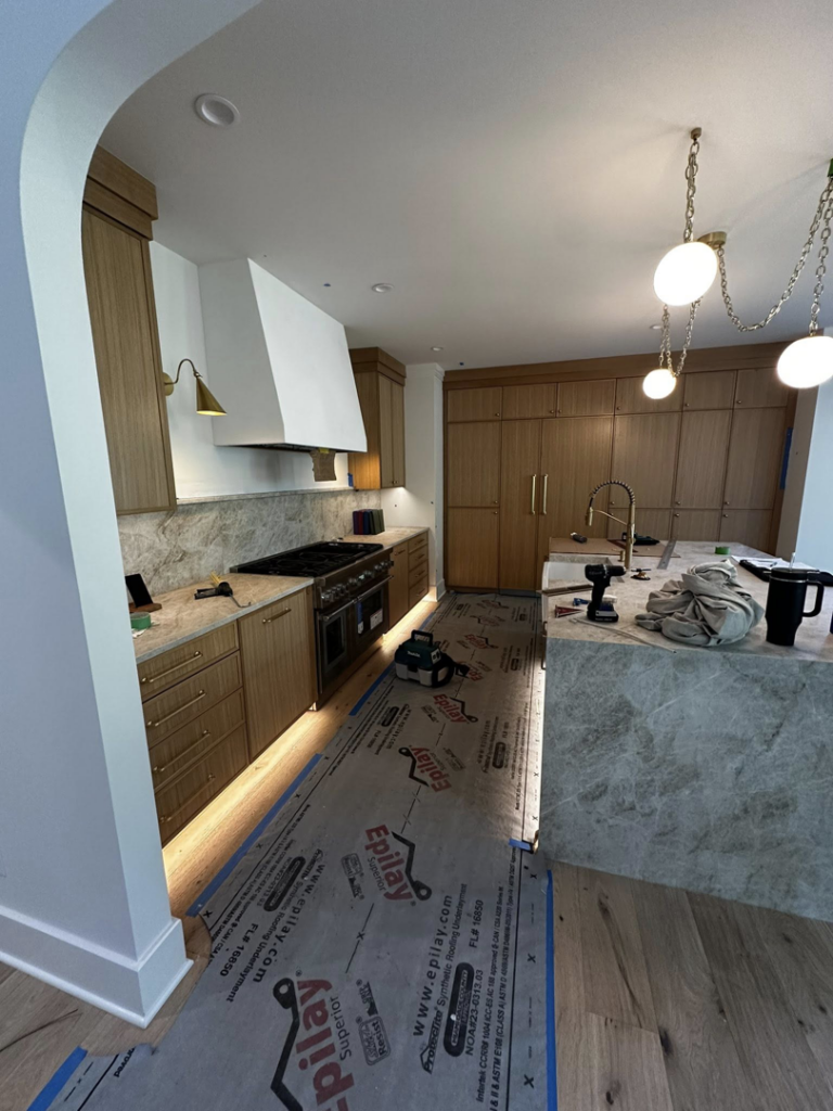 Kitchen lighting installation featuring under-cabinet, pendant, and recessed lights by Ampler Electrical Services in Wilmington, NC.