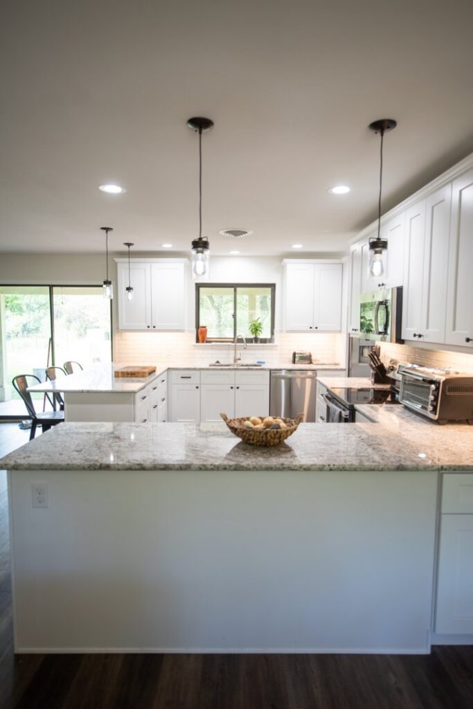 A view of a kitchen with new pendant and recessed lighting, part of an electrical upgrade by Molitor Electric in Austin, TX.