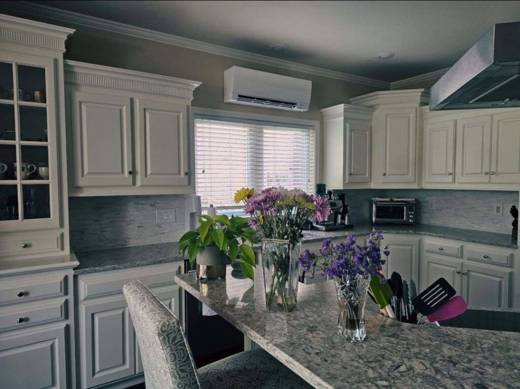 An indoor mini-split HVAC unit installed above a kitchen window by Cool y Caliente HVAC Services in Bonner Springs, KS.