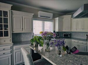 An indoor mini-split HVAC unit installed above a kitchen window by Cool y Caliente HVAC Services in Bonner Springs, KS.