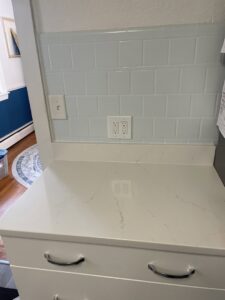 New electrical outlets and light switches installed on a kitchen backsplash by Common Ground Electrical in Baltimore, MD.