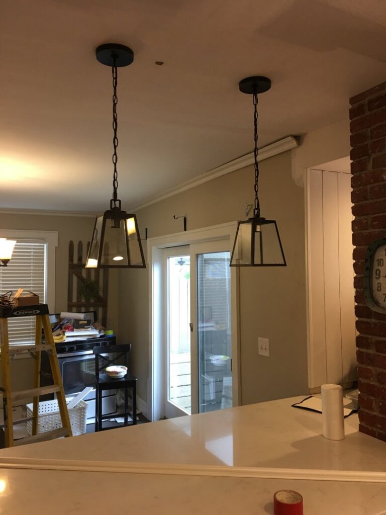 Two modern pendant lights professionally installed over a kitchen island, a lighting service by RHS Electrical Services in Westerville, OH.
