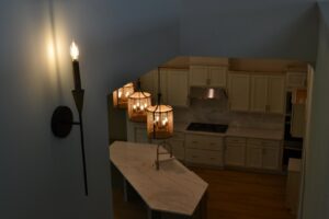 Newly installed kitchen pendant lights over an island and a wall sconce by Precision Electric and Lighting Services in Olive Branch, MS.