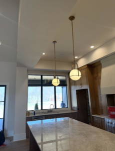 New pendant lights and recessed ceiling lights installed in a modern kitchen by HMH Electric in Fayetteville, AR.