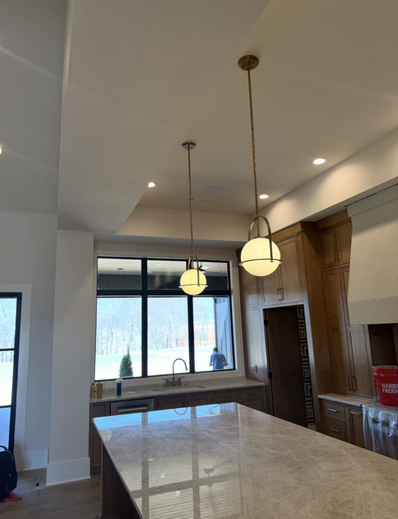 New pendant lights and recessed ceiling lights installed in a modern kitchen by HMH Electric in Fayetteville, AR.