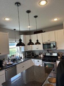 A newly updated kitchen featuring modern pendant lights and recessed lighting installed by LeBrun Electric, Heating & Cooling in Brooklyn Park, MN.