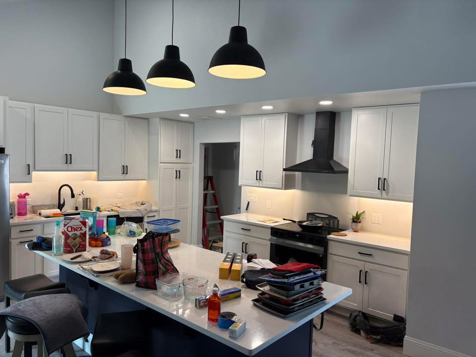 A bright kitchen showcasing new pendant, recessed, and under-cabinet lighting installed by JayCo Lighting & Electric in Colorado Springs, CO.