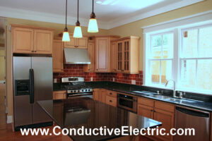 A modern kitchen with pendant lights and under-cabinet lighting installed by Conductive Electrical Contracting in Smyrna, DE.