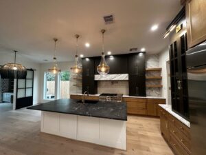 A modern kitchen featuring stylish pendant lights and functional under-cabinet lighting, installed by Volt-Pro Electric, LLC in Houston, TX