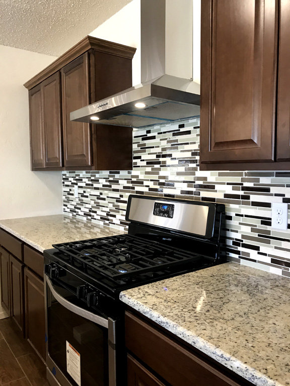 A newly installed kitchen range hood and gas stove by Home Repair Contractors in Las Cruces, NM