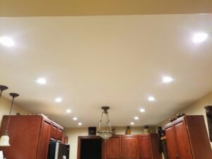 A kitchen featuring extensive recessed lighting and a central chandelier installed by MDEC Electrical & Lighting in Livonia, MI.