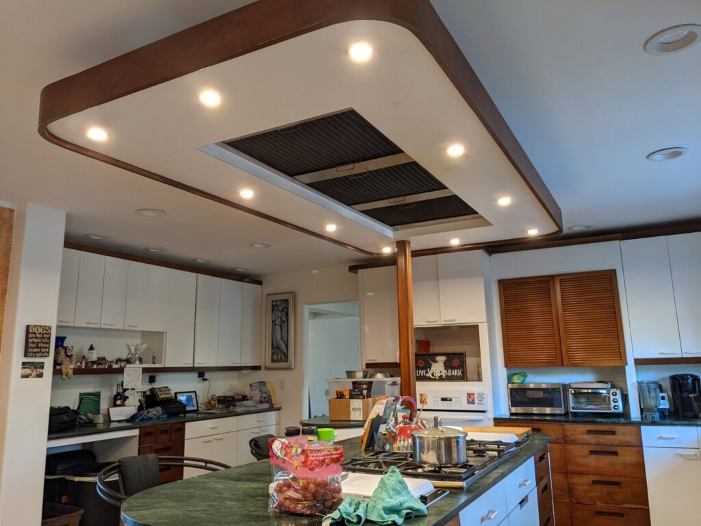 A modern kitchen featuring recessed lighting and a range hood, showcasing electrical installations by Primo's Electrical Services in San Diego, CA.