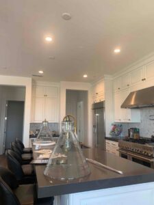 A modern kitchen showcasing newly installed recessed and pendant lighting over an island by AAA Electrical Services in Sacramento, CA.