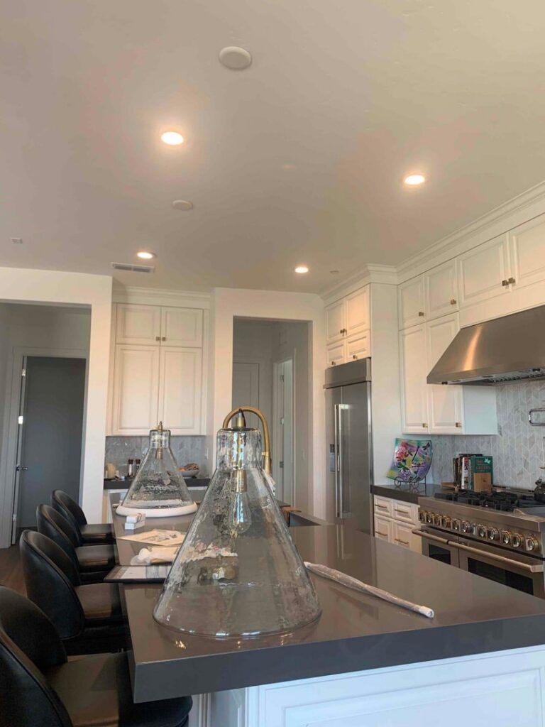 A modern kitchen showcasing newly installed recessed and pendant lighting over an island by AAA Electrical Services in Sacramento, CA.