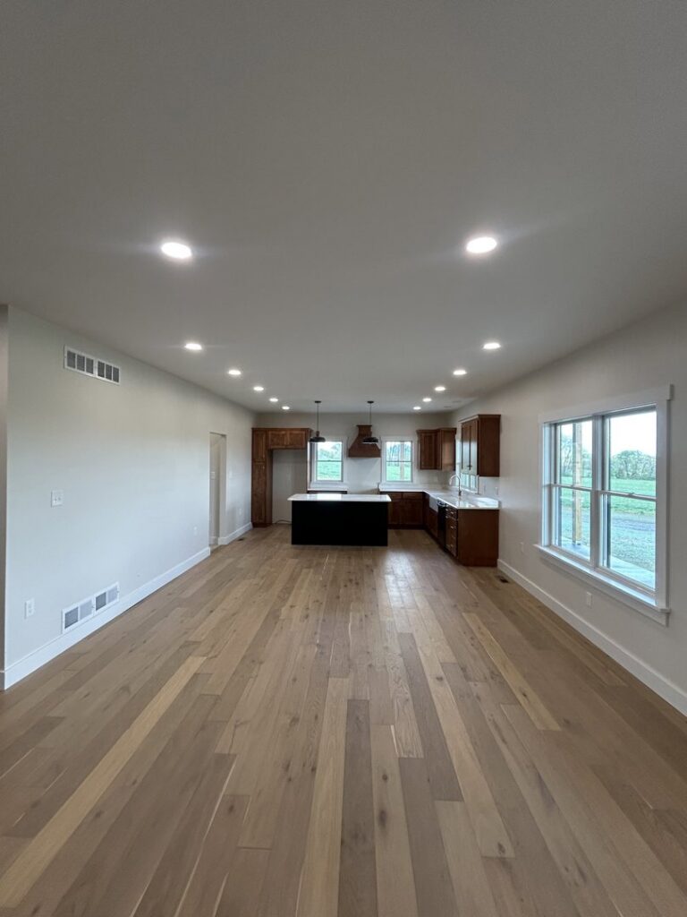 An open-concept kitchen and living area with recessed lighting and a pendant light over the island, installed by Superior Electrical Solutions llc in Clear Spring, MD.