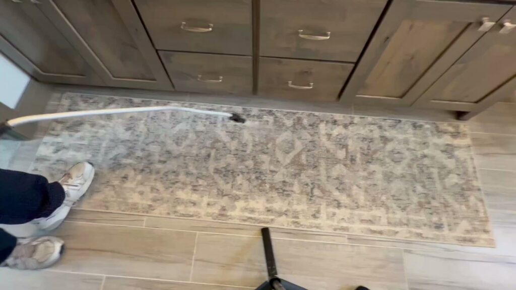 A Champion Chem-Dry technician cleaning a kitchen runner rug with a specialized tool in Idaho Falls, ID.
