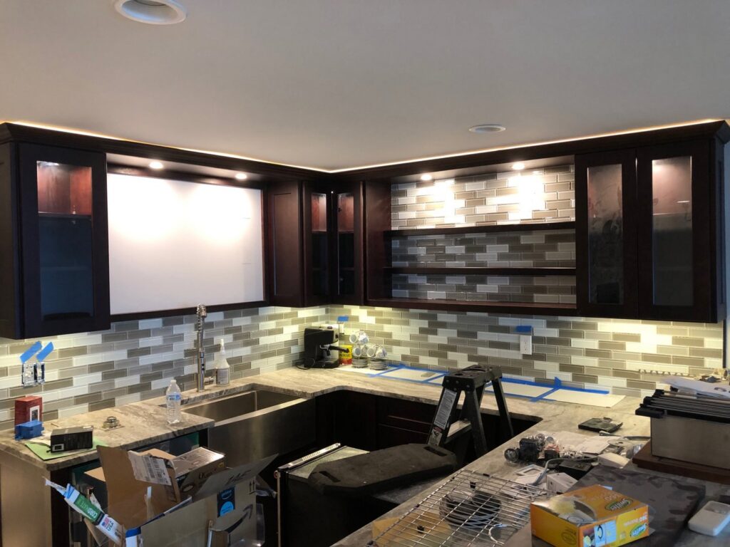 Modern kitchen with newly installed under-cabinet and accent lighting by Bacon Electric, LLC in Concord, NH.