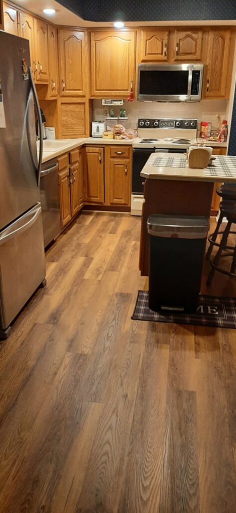 A kitchen showcasing a recent wood-look flooring installation by Carpet Warehouse in Lafayette, IN.