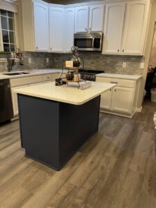 A modern kitchen featuring new wood-look flooring installed by Trent's Carpet Cleaning & Restoration in Fishers, IN.