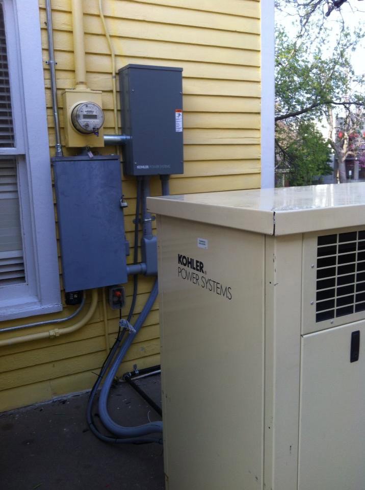 A Kohler power systems generator and electrical panels installed on the exterior of a house by Natural State Electric LLC in Fayetteville, AR.