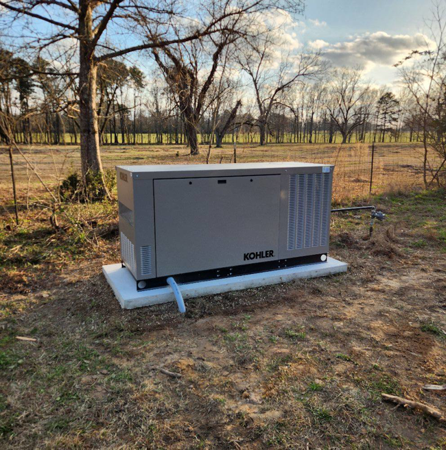 A Kohler standby generator installed on a concrete pad in a rural setting by GenTec Service and Repair in Bossier City, LA