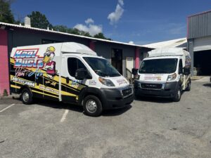Two Kool Ducts Heat & Air branded service vans parked outside the business location in Wilmington, NC.